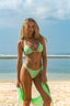 Mujer posando con bikini y pareo de mesh color verde neón